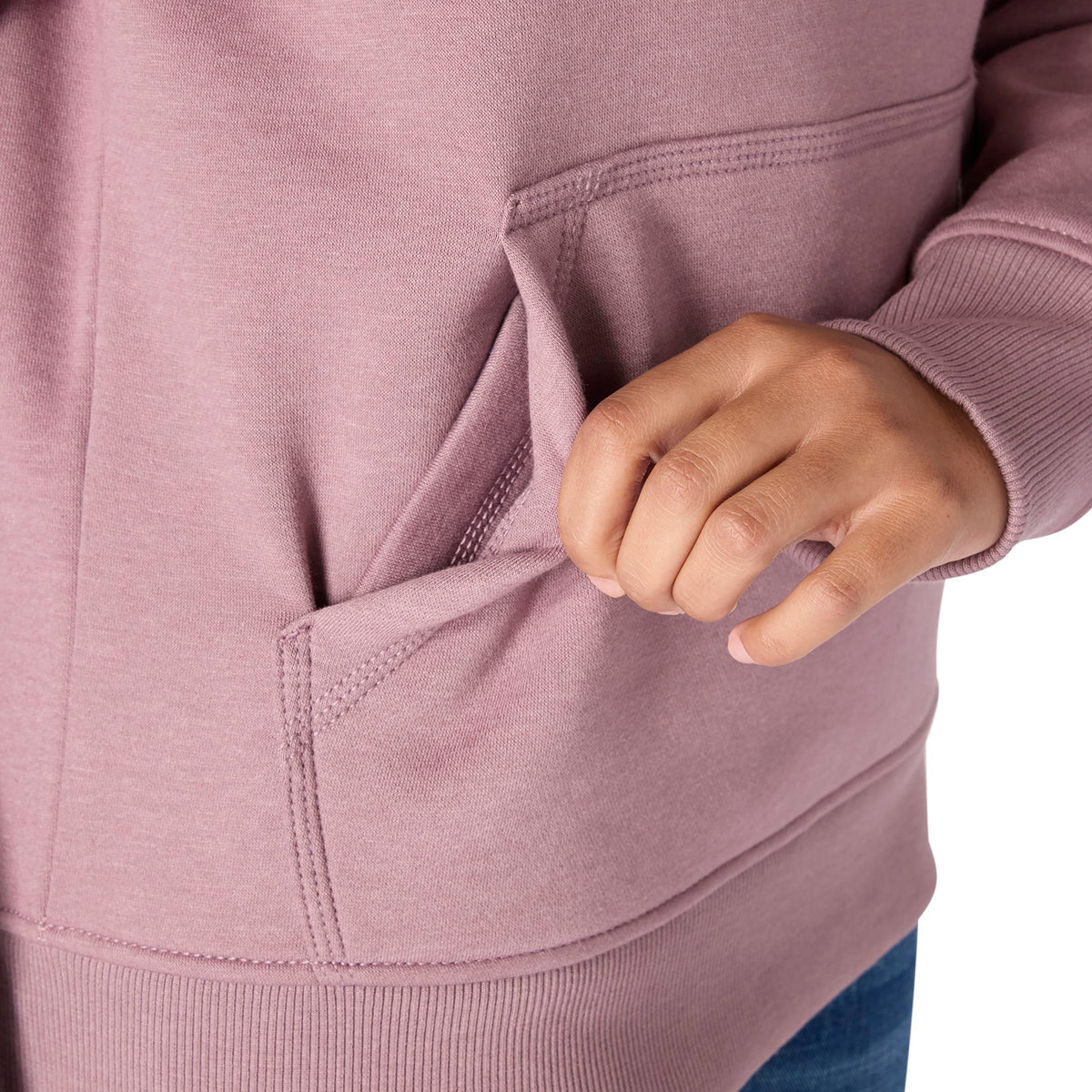 Close-up of a person wearing a pink hoodie with a hand in the pocket.